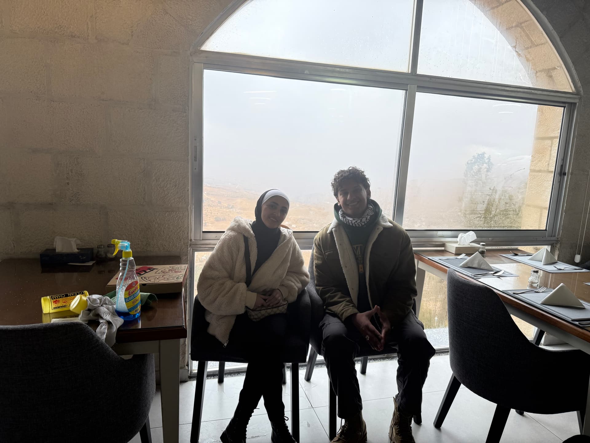 Two people talking by a window — dialect lives here, not on the page